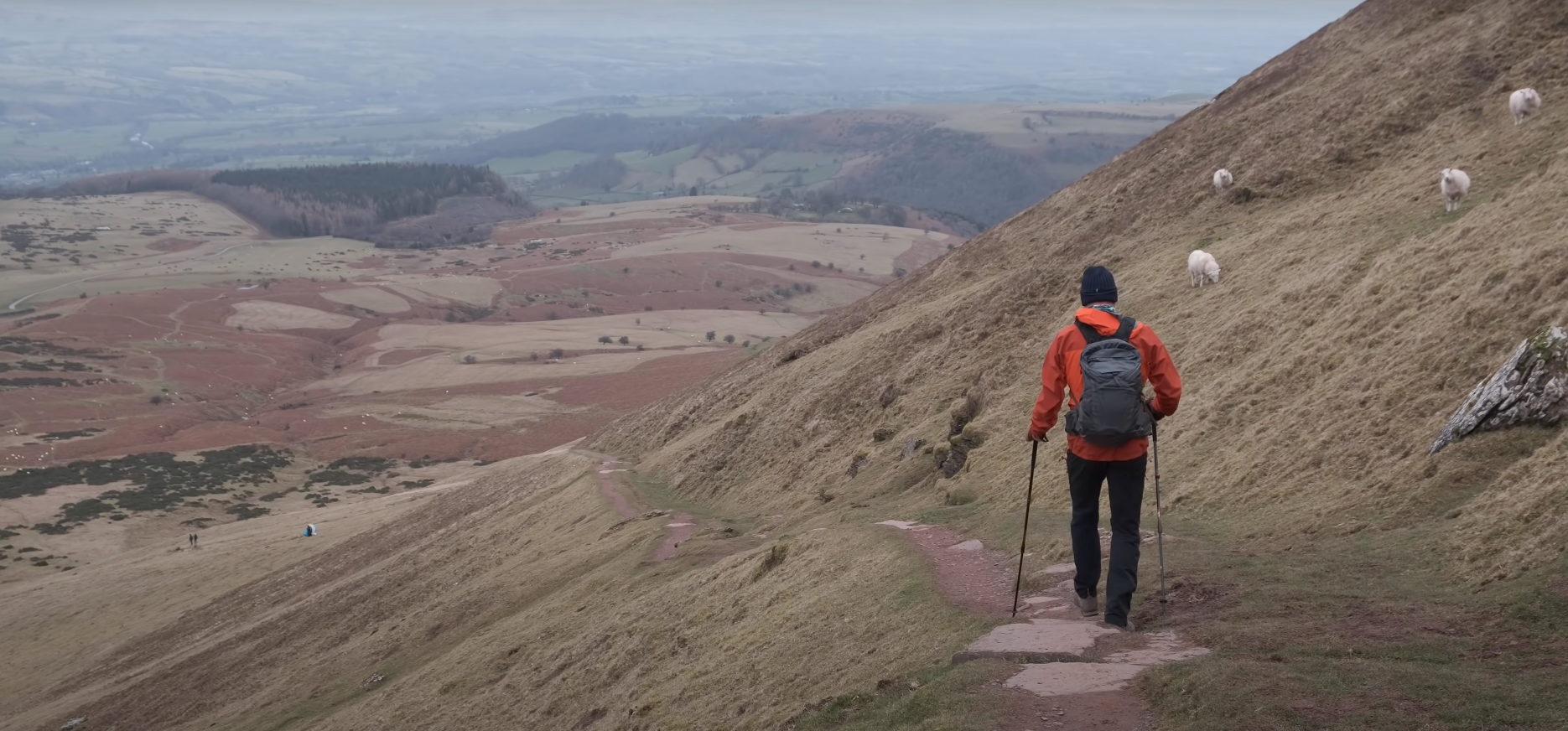 Paul walking with walking poles along Pen Y Fan