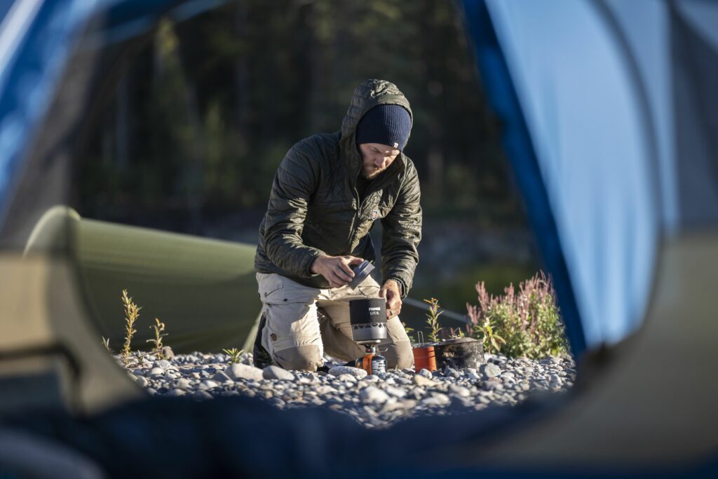 Using stove heat outside the tent to gently warm damp gear before airing it inside