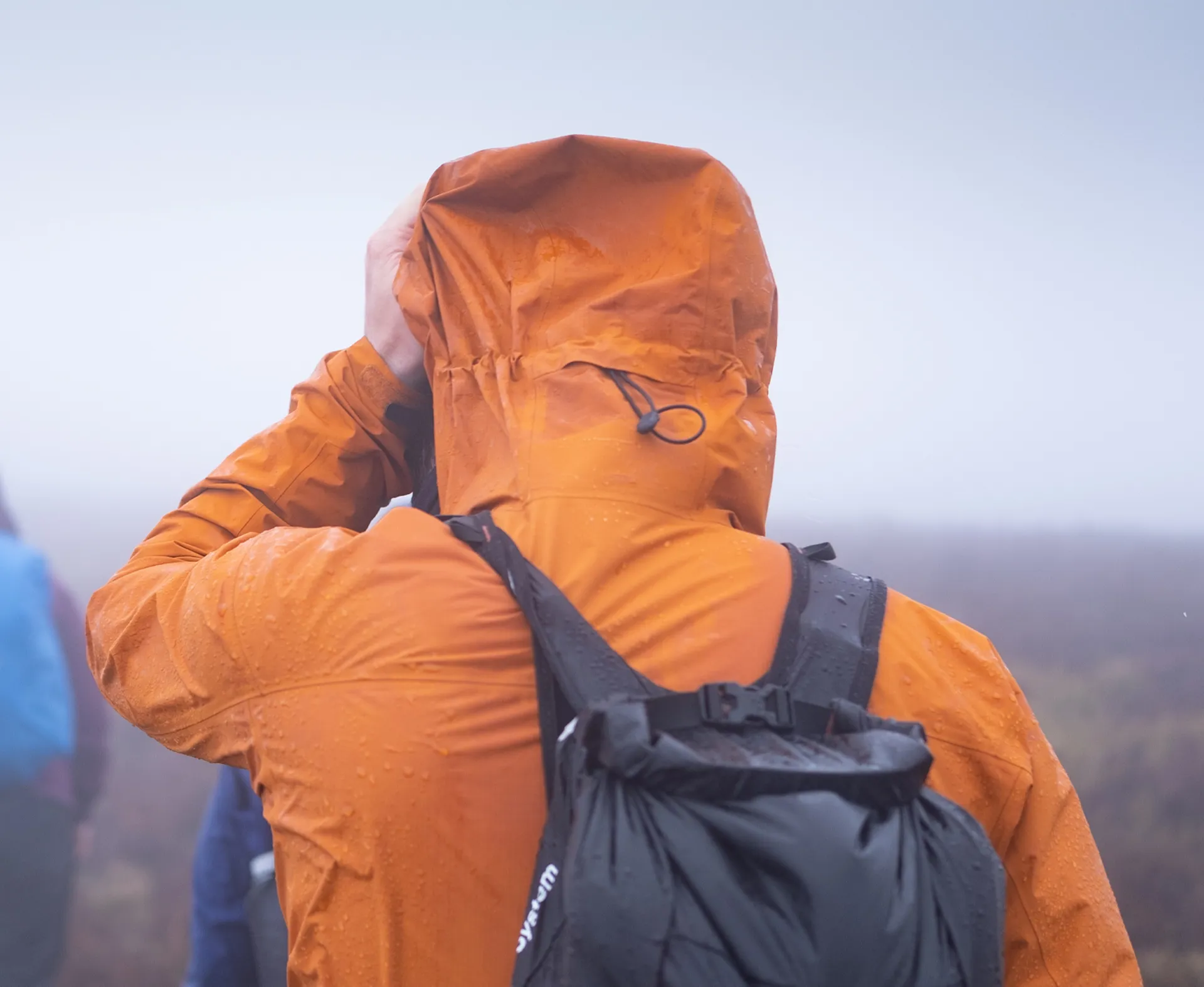 Cinchable hem and high-wear areas on a hiking waterproof jacket